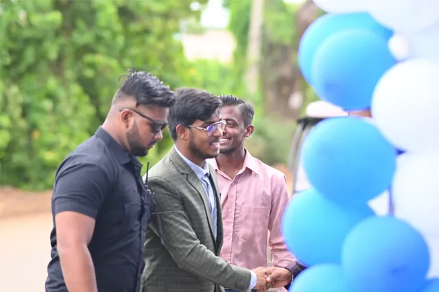 Roshan Burnwal at an outdoor DROP fifth anniversary celebration with blue and white balloons.