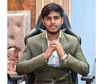 Roshan Burnwal seated in a green checked suit